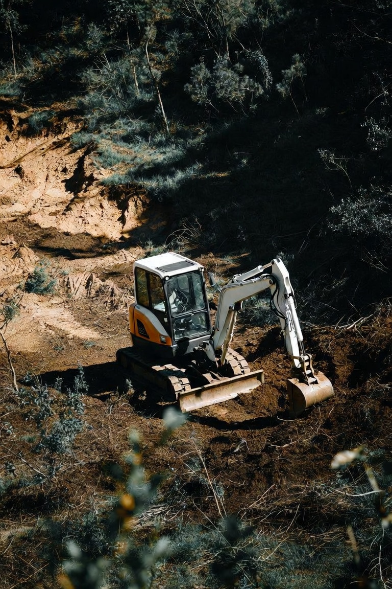 Excavator with breaker tackling a landscape removal job